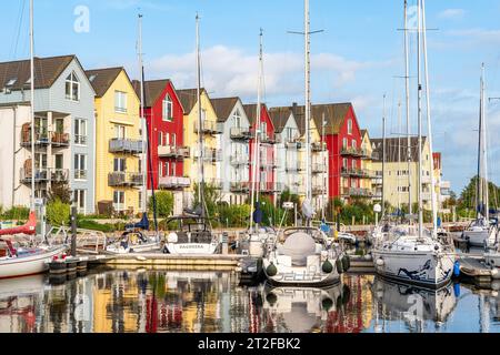 Yacht a vela e case colorate con appartamenti per vacanze nel porto di Greifswald, Meclemburgo-Vorpommern, Germania Foto Stock