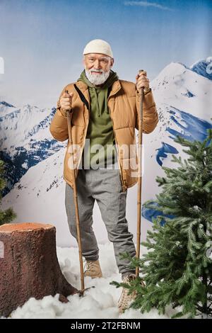 Babbo Natale sportivo con giacca calda e cappello bianco in piedi sugli sci vicino al ceppo di alberi, concetto invernale Foto Stock