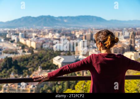 Un giovane turista che guarda le vedute della città e della Cattedrale dell'Incarnazione di Malaga dal Castello di Gibralfaro nella città di Malaga Foto Stock