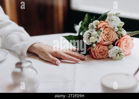 Un bel bouquet di rose sul tavolo servito e decorato per la cena Foto Stock