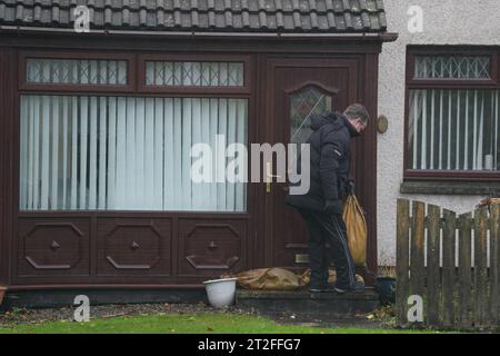 Un residente mette dei sacchi di sabbia fuori dalla sua porta mentre lascia la sua casa su River Street a Brechin. Il Regno Unito si sta alleando per il vento pesante e la pioggia di Storm Babet, la seconda tempesta nominata della stagione. In alcune zone della Scozia è stato emesso un raro segnale meteorologico rosso che indica che esiste un "rischio per la vita", poiché si prevede che la tempesta colpirà il Regno Unito giovedì. Data immagine: Giovedì 19 ottobre 2023. Foto Stock