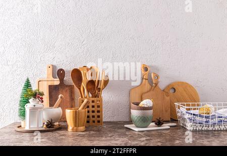 Set di diversi taglieri in legno e utensili da cucina con decorazioni natalizie su ripiano cucina in marmo. Vista frontale. Uno spazio per le copie Foto Stock