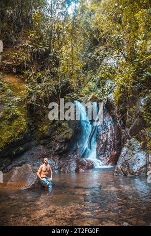 Un giovane uomo nell'imponente cascata del Parco Nazionale del Cerro Azul Meambar (Panacam) a Yojoa. Honduras Foto Stock