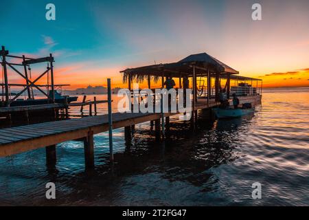 Un molo e la barca sullo sfondo su una spiaggia sull'Isola di Roatan. Honduras Foto Stock