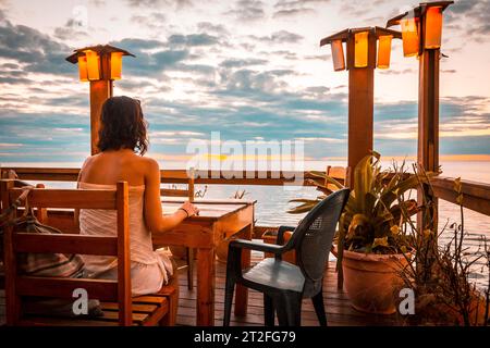 Roatan, Honduras Â», gennaio 2020: Una giovane donna in un ristorante del West End sull'isola di Roatan in un tramonto Foto Stock