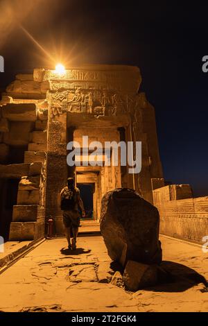 Un giovane che visita di notte il Tempio illuminato di Kom Ombo, il tempio dedicato agli dei Sobek e Horus. Città di Kom Ombo vicino ad Aswer, Egitto Foto Stock