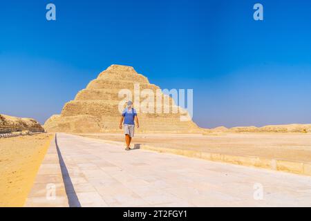 Un giovane che cammina nella piramide a gradini di Djoser, Saqqara. Egitto. La necropoli più importante di Memphis. La prima piramide al mondo Foto Stock