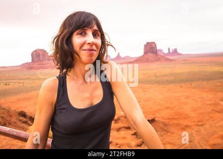 Una giovane donna che guarda in un Nuvoloso Monument Valley National Park. Utah Foto Stock