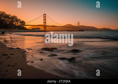 San Francisco, California Stati Uniti Â», agosto 2019: Lunga esposizione al tramonto rosso al Golden Gate di San Francisco dalla spiaggia Foto Stock