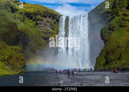 La famosa cascata visitata da centinaia di turisti giornalieri, foto dal fiume, la cascata Skogafoss nel cerchio dorato del sud dell'Islanda Foto Stock
