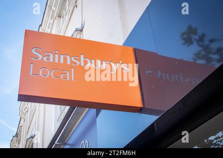 Londra - 10 ottobre 2023: Sainsbury's Local, filiale di supermercato britannico, logo/segnaletica esterna Foto Stock