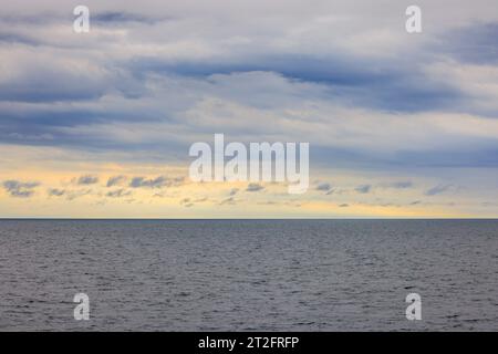 Orizzonte lontano tra lo strato di nuvole e i mari calmi all'alba Foto Stock