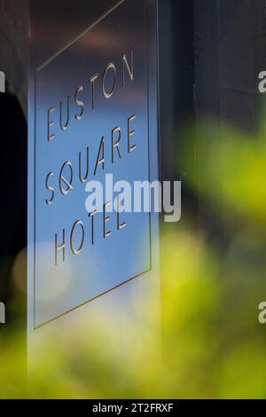 Marchio Euston Square Hotel sulla parete esterna dietro un morbido fogliame in primo piano. Solo per uso editoriale. Foto Stock