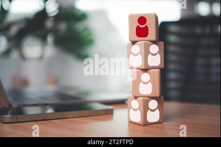 Un blocco di legno ha la leadership e si distingue con l'icona rossa del manager posizionata sul tavolo come concetto di gestione delle risorse umane per la leadership e il lavoro di squadra. Foto Stock