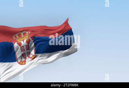 Bandiera nazionale serba che sventola nel vento in una giornata limpida. Bande rosse, blu e bianche, con stemma serbo a sinistra del centro. illustrati 3d. Foto Stock