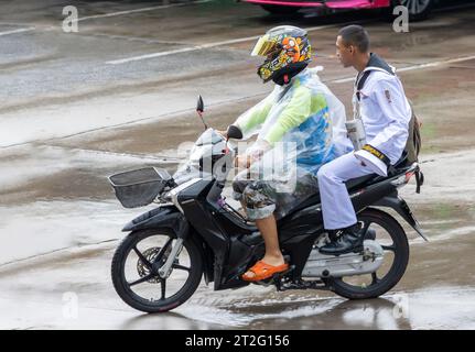 SAMUT PRAKAN, THAILANDIA, 20 settembre 2023, Un moto-taxi guida con un marinaio sulla strada piovosa Foto Stock