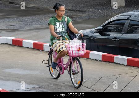 SAMUT PRAKAN, TAILANDIA, 20 settembre 2023, Una donna che va in bicicletta in una strada cittadina. Foto Stock