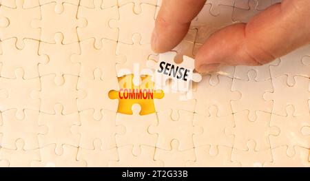 Simbolo di buon senso. Parole concettuali Common Sense su un bellissimo puzzle di white paper. Splendido sfondo giallo. Mano d'affari. Affari, motivazione Foto Stock