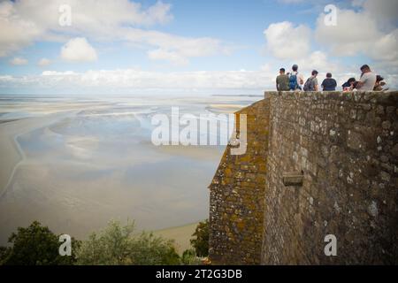 MONT SAINT MICHEL, AGOSTO 2023 - i turisti ammirano la vista della baia con la bassa marea, dalle mura dell'Abbazia di Mont Saint Michel in una giornata estiva. Foto Stock