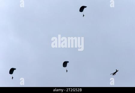 Drei Fallschirmaufklärer der Schweizer Armee an Freifallschirmen über der Axalp. Rechts im Bild das Flugzeug, aus welchem diese abgesetzt wurden, ein Pilatus PC-6 Porter. Flugvorführungen der Schweizer Luftwaffe auf dem Fliegerschiessplatz Axalp-Ebenfluh AM 18. Oktober 2023. Axalp ob Brienz Kanton Bern Schweiz *** tre aerei da ricognizione paracadutisti dell'esercito svizzero con paracadute liberi sull'Axalp proprio nella foto l'aereo da cui sono stati sganciati, un Pilatus PC 6 Porter Flight dimostrazioni della Swiss Air Force presso la base aerea Axalp Ebenfluh il 18 ottobre 2023 Axalp ob Bri Foto Stock