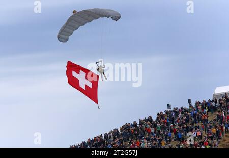 Ein Freifaller der Schweizer Armee mit Schweizer Flagge über den Zuschauern auf der Axalp. Flugvorführungen der Schweizer Luftwaffe auf dem Fliegerschiessplatz Axalp-Ebenfluh AM 18. Oktober 2023. Axalp ob Brienz Kanton Berna Schweiz *** Un Faller libero dell'esercito svizzero con bandiera svizzera sopra gli spettatori delle dimostrazioni di volo dell'Axalp Swiss Air Force presso il raggio di tiro dell'aeronautica di Axalp Ebenfluh il 18 ottobre 2023 Axalp ob Brienz Canton Berna Svizzera credito: Imago/Alamy Live News Foto Stock