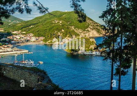 Pittoresca vista panoramica di Parga, Grecia. Baia idilliaca, case tradizionali, porto e una piccola isola in un paradiso mediterraneo con il Mare Blu. Foto Stock