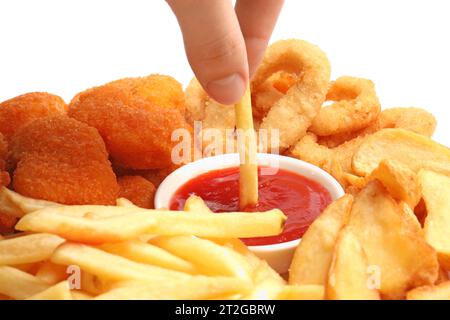 Donna che immerge la frittura francese in una ciotola con un gustoso ketchup su sfondo bianco, primo piano Foto Stock