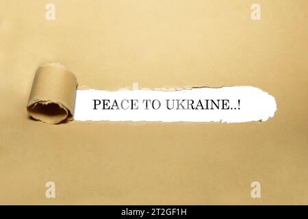 Citazione testuale di "pace in ucraina” che appare dietro carta marrone lacerata. Foto Stock