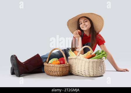 Piccolo agricoltore con cibo fresco su sfondo chiaro Foto Stock