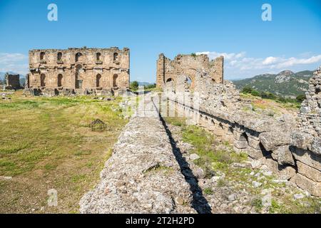 Rovine del ninfeo (fontana monumentale) e della basilica sulla collina dell'acropoli di Aspendos, antico sito in Turchia. Foto Stock