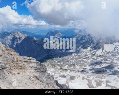 Splendido paesaggio con montagne alpine e cielo nuvoloso. Cime innevate in Baviera. Vista dalla piattaforma di osservazione in cima a Zugspitze. Germania. Foto Stock