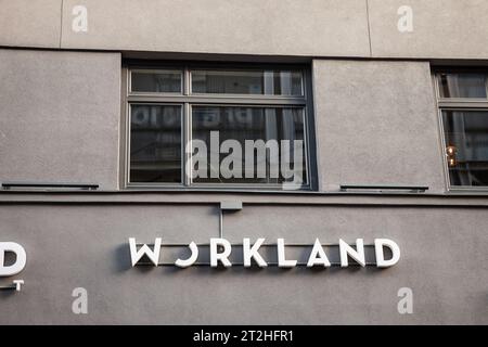 Immagine del logo di Worland davanti al loro spazio di coworking per riga. Workland è una catena immobiliare lettone specializzata nel coworking e nell'ufficio Foto Stock