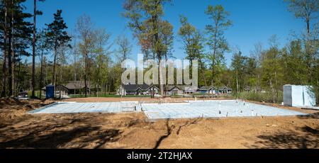 CROW WING CO, Minnesota - 10 MAGGIO 2023: Un bel lotto di edifici boscosi è un cantiere di costruzione di abitazioni con isolamento sul pavimento di cemento, in una giornata di sole Foto Stock