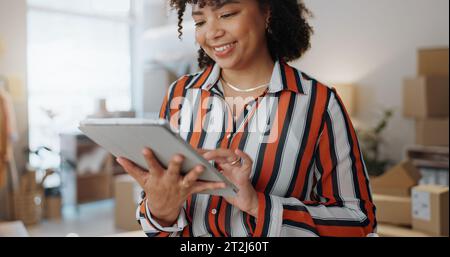 Donna d'affari, sorriso e tablet in ufficio per la logistica, la comunicazione o l'e-mail con il magazzino. Stilista di moda, distribuzione e pacchi per il cliente Foto Stock