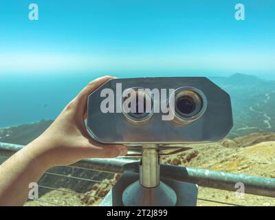 piattaforma di osservazione con binocolo con grandi lenti nere contro il cielo. lente d'ingrandimento ambientale. binocolo panoramico per i turisti, un uomo lo tiene Foto Stock