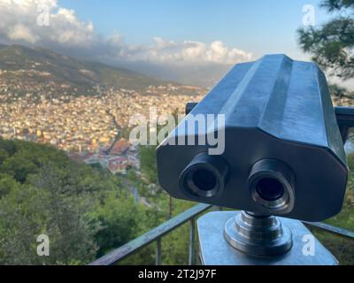 Binocolo, vetro spia per osservare il paesaggio e le attrazioni su una terrazza panoramica che si affaccia sulla città in un caldo tropicale tropicale di campagna sou Foto Stock