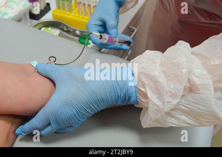 Primo piano del medico che preleva un campione di sangue dal braccio del paziente. Foto Stock