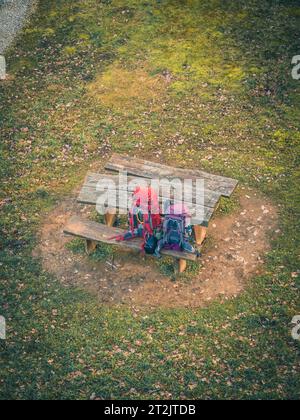 Due zaini da trekking per arrampicata su una panchina di legno rossa viola, senza persone, vista aerea con droni Foto Stock