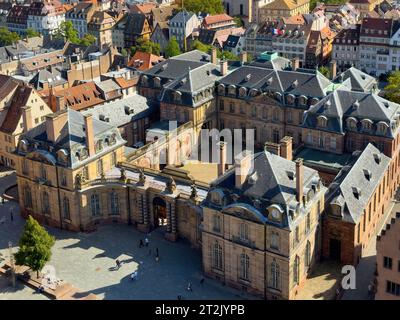 Prospettiva aerea: Lo splendido Palais Rohan, situato in posizione centrale a Strasburgo, circondato da piccole sagome di persone e adagiato sullo sfondo affascinante di edifici alsaziani in legno, un'incantevole visita a Strasburgo, in Francia. Foto Stock