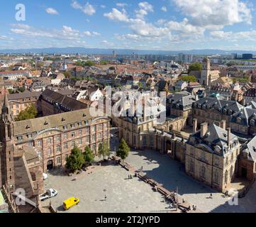 Vista aerea di autunno in Alsazia: Sagome di persone vicino alla scuola Fustel-De-Coulanges e all'edificio Palais Rohan sotto un cielo nuvoloso Foto Stock