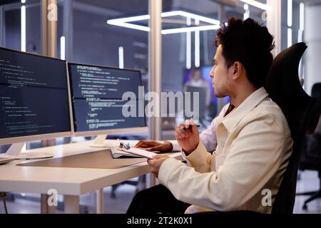 Programmatore di computer che scrive il codice di programma sul computer in Office Foto Stock