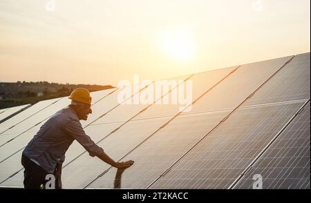 Uomo che lavora alla stazione dei pannelli solari - concetto di energia verde rinnovabile - Focus on Face Foto Stock