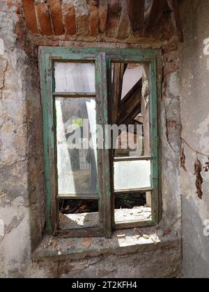 Facciata dell'edificio fatiscente. Intonaco esterno incrinato e sbucciato su pareti in mattoni e vecchie telai delle finestre, niente persone Foto Stock