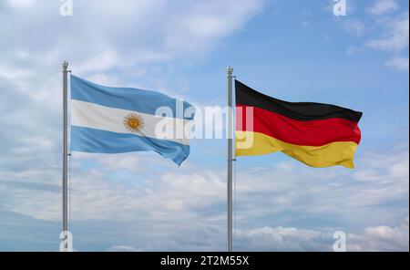 Le bandiere di Germania e Argentina sventolano insieme su un cielo nuvoloso blu, concetto di relazione tra due paesi Foto Stock