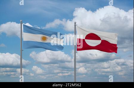 Le bandiere della Groenlandia e dell'Argentina sventolano insieme sul cielo nuvoloso blu, concetto di due relazioni tra paesi Foto Stock