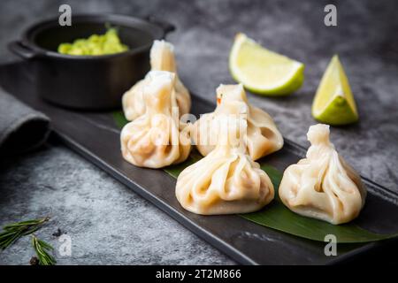 succosa khinkali con salsa su una tavola nera con vista laterale Foto Stock