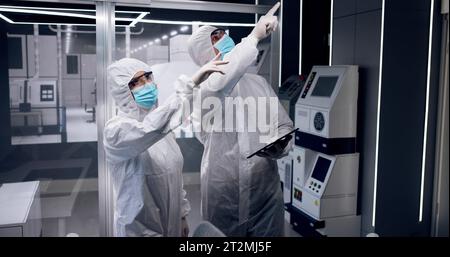 Fabbrica di produzione di semiconduttori sterile e lavoratori in tute Foto Stock