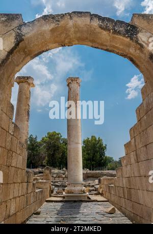 Beit Shean, Israele - 13 agosto 2023: Rovine di un arco romano con una colonna al centro del Beit Shean National Park, Israele Foto Stock