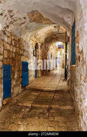 Una stretta strada acciottolata o vicolo nel quartiere ebraico della città più alta di Israele, Tzafet (Safed). Traduzione dei segni: Rabbi Moshe Elsheich Foto Stock