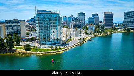 Barca a vela solitaria sul lago Merritt di fronte alle Eastshore Properties in un'area aerea di edifici del centro Foto Stock